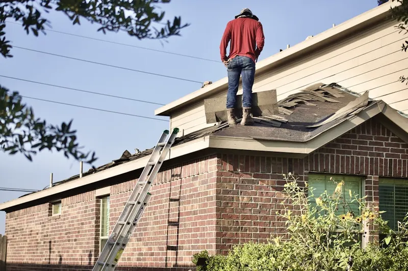 Professional roofer working on a residential roof in Del Haven